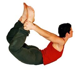 8. Bogen: An die Fußgelenke fassen, Füße und Brustkorb heben. Stärkt die Oberschenkel und die Rückenmuskeln. Dehnt die Oberschenkelmuskeln (Quadrizeps), die Psoasmuskeln, Bauch, Brust und Kehle.