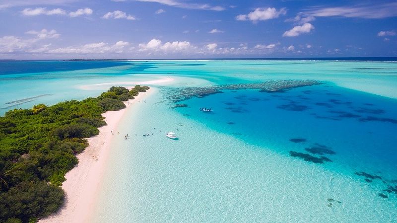 Datei:Tropische Insel weißer Sand Türkis blau Wasser Sonne.jpg