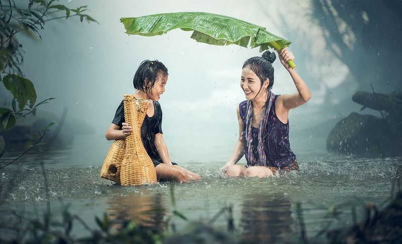 Datei:Regen Regenschutz Wasser Nass Thailand Mädchen lachen.jpg