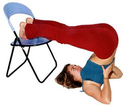 Pflug mit Stuhl: Aus dem Schulterstand heraus die Beine gestreckt nach hinten geben. Hände unterstützen den Rücken. Nur so lange halten, wie angenehm.