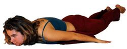 Kissen oder Decke unter Bauch und Hüftknochen, sodass die Rückenmuskeln ohne Rückbeuge gestärkt werden können.