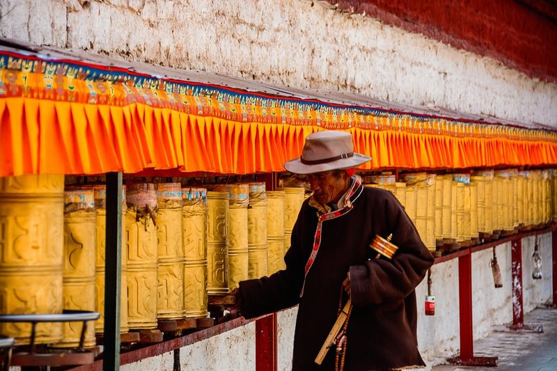 Datei:Lhasa Pilger spirituelle Praxis Gebetsmühle.jpg