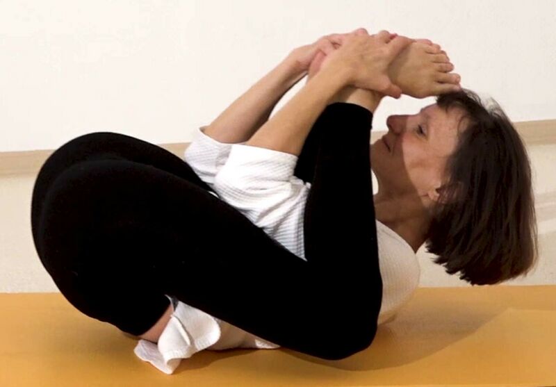 Datei:Sanfte Yoga Schlafstellung mit Fuessen vor dem Kopf - Yoga Nidrasana Variation.jpg