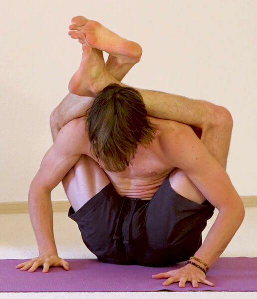 Datei:Fuss-hinter-dem-Kopf-Stellungen im Sitzen Stehen und Liegen Eka Pada Shirasana Yoga Posen Variationen 2 Sitzend mit beiden Fuessen.jpg