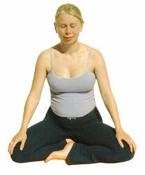 Meditationssitz: Setze dich kreuzbeinig hin auf ein Kissen. Entspanne Schultern, Beine und Gesäß, Wirbelsäule gerade, Hände auf den Knien oder Oberschenkeln.