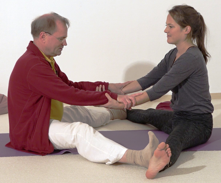 Datei:In die sitzende Graetsche helfen - Yoga Vidya Bodywork 3.png