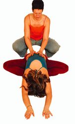 (3) ... bis der Kopf vor den Füßen auf dem Boden ist. Arme dabei nach vorne ausstrecken. Hier auf dem Bild hilft die Yogalehrerin mit...